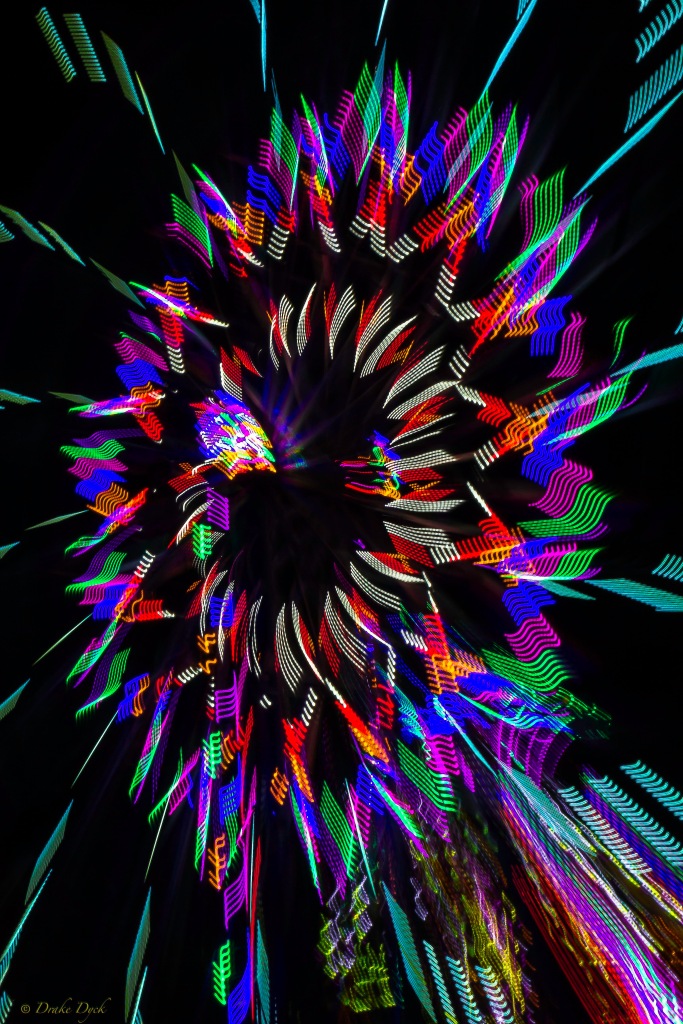 pinwheel looking lights of a ferris wheel at night